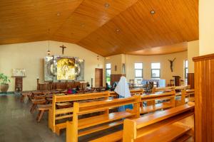 a large church with wooden pews and a cross on the wall at Kibeho Pilgrimage Center in Giseke