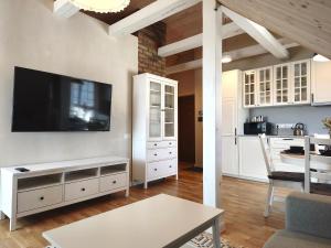 a living room with a flat screen tv on a wall at Loft Apartment Self Check-in in Mažeikiai