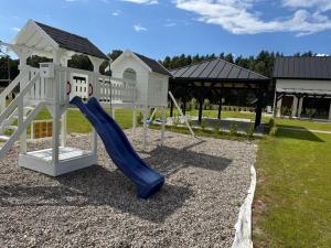 a playground with a slide and a play structure at FORESTA in Redliny