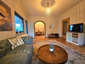 a living room with a couch and a table at Selker Noor Apartments - 1,4 ha Naturpark, privater Terrasse, Bachlauf an der Selker Wassermühle in Schleswig