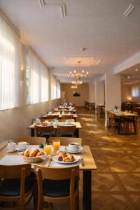 a long dining room with tables with food on them at REGIOHOTEL Bunte Stadt Wernigerode in Wernigerode