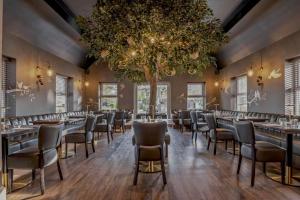 a room with tables and chairs and a tree at The Kinmel & Kinspa in Abergele