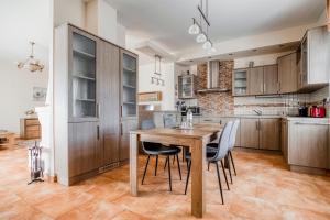 a kitchen with a wooden table and chairs at Villa Walir - Spa Hotel Garni SUPERIOR in Mariánské Lázně +30 photos