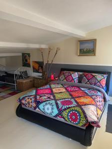 a bed with a colorful quilt in a bedroom at La Belle Vue in Ganges +73 photos
