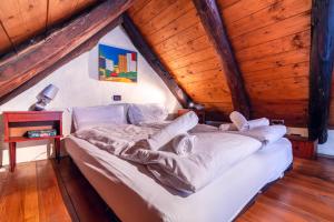 a bed in a room with a wooden ceiling at Centovalli Rustic near Locarno in Intragna