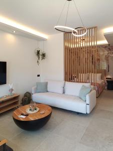 a living room with a white couch and a table at Th Tsimas Luxury studio 4 in Skala Potamias