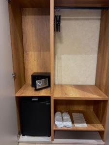 a wooden cabinet with a microwave and a microwave at Shkoder City Center - Floir Hotel in Shkodër