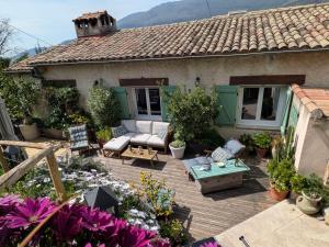 a house with a wooden deck with flowers in front of it at Charmant haut de villa in Châteauneuf
