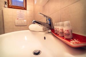 a bathroom sink with a faucet with toiletries on it at Centovalli Rustic near Locarno in Intragna