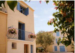 a building with two flower boxes on a balcony at Maison de Thau in Mèze