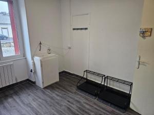 an empty room with a refrigerator and a window at Grand Duplex, 6 personnes in Besse-et-Saint-Anastaise