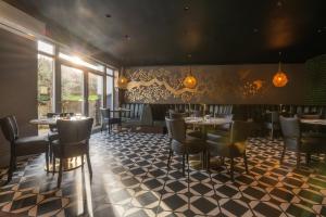 a dining room with tables and chairs and windows at The Kinmel & Kinspa in Abergele