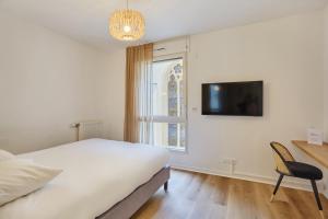 a bedroom with a bed and a chair and a window at MAISON SAINT CHARLES - ASSOCIATION HABITAT et HUMANISME ILE DE FRANCE in Paris