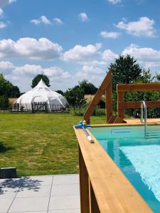 ein großes weißes Zelt auf einem Feld mit einem Schwimmbad in der Unterkunft Glamping & wellness Moonlight in Brakel