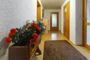 a hallway with a vase with red flowers in it at Ferienwohnung Goldhorn in Rödental