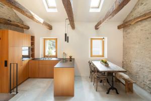 a kitchen with wooden cabinets and a wooden table at Charming Rustico Losone near Locarno in Losone +16 photos