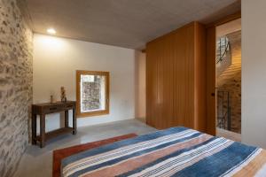 a bedroom with a bed and a table and a window at Charming Rustico Losone near Locarno in Losone
