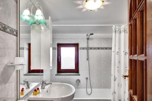 a bathroom with a tub and a sink and a shower at GOCCE VILLAS - Il Frantoio in Massa Lubrense