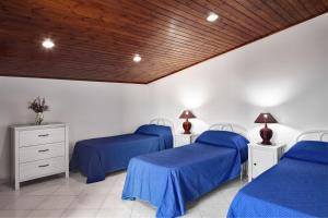 two beds in a room with blue sheets at GOCCE VILLAS - Il Frantoio in Massa Lubrense