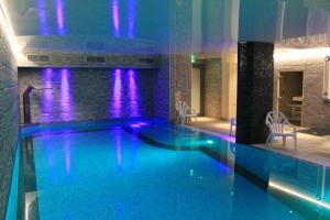 a swimming pool with purple lights in a building at Chalet Adelphine 1 & SPA in Les Gets