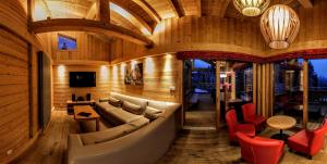 a living room with a large couch and red chairs at Chalet Adelphine 1 & SPA in Les Gets
