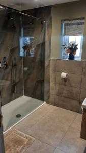 a shower with a glass door in a bathroom at Coastal Rest in Beadnell +23 photos