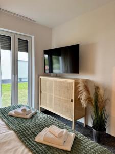 a bedroom with two towels on a bed with a tv at See you! in Pouch