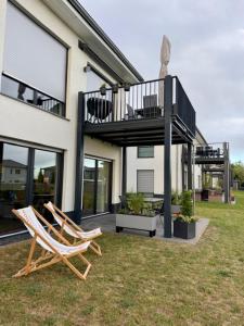 two chairs sitting in the grass in front of a house at See you! in Pouch