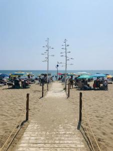 a sandy beach with umbrellas and people on the beach at Stella Sea House2 in Torvaianica