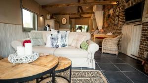 a living room with a white couch and a table at B&B Hoeve Westdijk in Oostkamp
