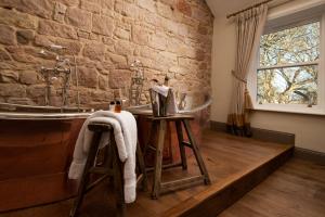 a bathroom with a stone wall and a tub at Beadnell Towers Hotel in Beadnell