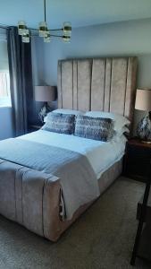 a bedroom with a large bed with a large headboard at Coastal Rest in Beadnell