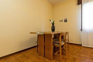 a table with chairs and a vase with flowers on it at Sleep & Fly - Immobili e Soluzioni Rent in Orio al Serio