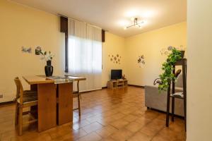 a living room with a table and a room with a television at Sleep & Fly - Immobili e Soluzioni Rent in Orio al Serio +19 photos