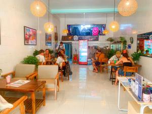 a group of people sitting at tables in a restaurant at Social Backpacker Hostel & Rooftop Bar in Battambang