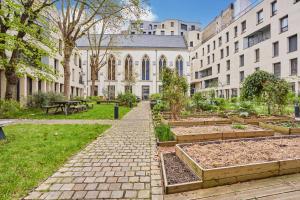 a garden in front of a building with trees and plants at MAISON SAINT CHARLES - ASSOCIATION HABITAT et HUMANISME ILE DE FRANCE in Paris