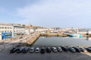 a group of cars parked in a parking lot next to a harbor at Le Barracuda & Spa, pieds dans l'eau, vue mer, espace bien-être offert in Brest