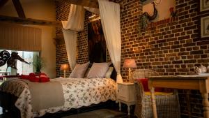 a bedroom with a bed and a brick wall at B&B Hoeve Westdijk in Oostkamp