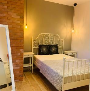 a bedroom with a white bed with two night stands at Tarnowskiego City Apartaments in Kutno