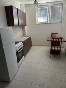 a kitchen with a white refrigerator and a table at Salihu in Ferizaj