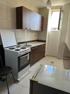 a kitchen with a stove and a sink and a window at Salihu in Ferizaj