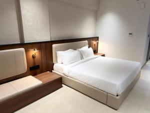 a bedroom with a large white bed and a couch at Hotel Waterlily in Indore