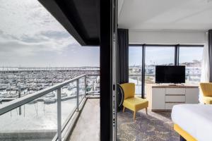 a bedroom with a balcony with a view of a harbor at Le Barracuda & Spa, pieds dans l'eau, vue mer, espace bien-être offert in Brest