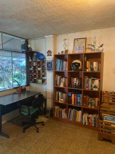a room with a desk and a book shelf with books at El Barquero in Puerto Baquerizo Moreno