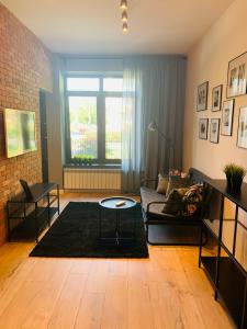 a living room with a couch and a table at Tarnowskiego City Apartaments in Kutno