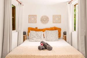 a bedroom with a bed with a stuffed animal on it at Canopy Lodge - Perfect Mauritius Trip in Tamarin