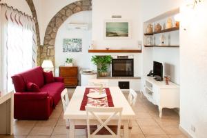 a living room with a red couch and a table at Casale Gli Ulivi in Orbetello