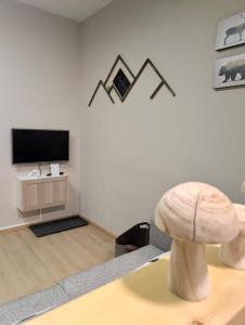 a living room with a tv and a table with a stool at Bosco Verde in Tarvisio