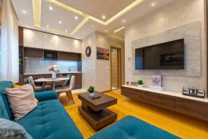 a living room with a blue couch and a table at Vila Pino Silvestre in Zlatibor