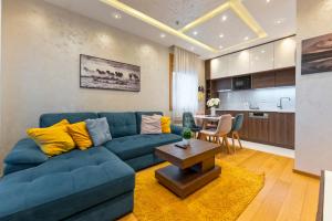 a living room with a blue couch and a table at Vila Pino Silvestre in Zlatibor